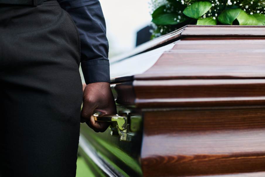 A somber image accompanying a legal discussion about loss of sepulcher claims, focusing on a pallbearer carrying a dark wooden casket.